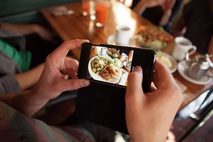 Framed Print : Cropped shot of man taking photograph of meal in vegetarian restaurant Framed Print : Cropped shot of man taking photograph of meal in vegetarian restaurant