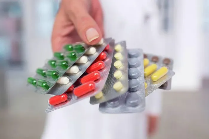 Framed Print : Cropped view of doctor holding pills in blister packs Framed Print : Cropped view of doctor holding pills in blister packs