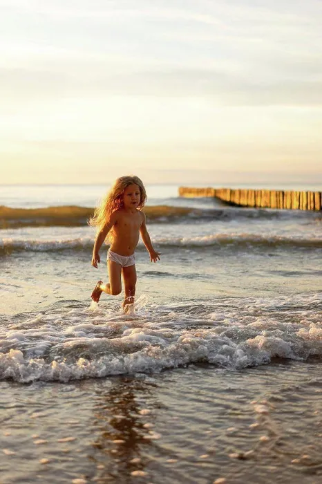 Framed Print : Cute girl wearing underwear playing in water on beach