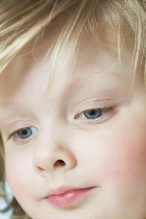 Framed Print : A cute little girl looking down, extreme close-up