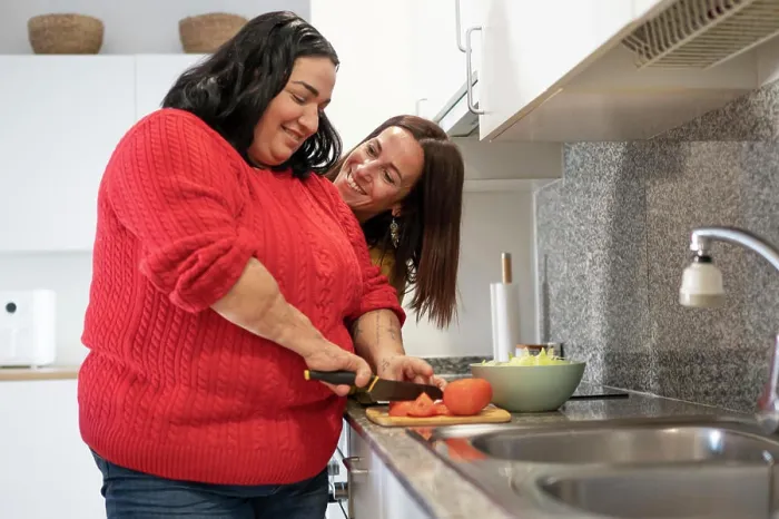 Framed Print : Two diverse friends preparing lunch in the kitchen with her friend Framed Print : Two diverse friends preparing lunch in the kitchen with her friend