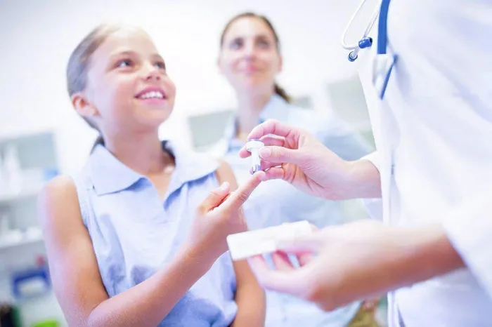 Framed Print : Doctor giving girl a finger prick test
