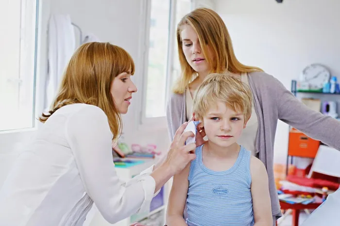 Framed Print : Doctor measuring a child's temperature