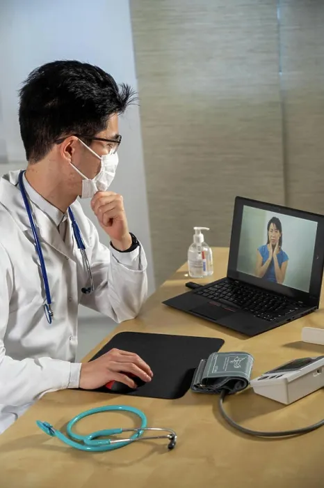 Framed Print : Doctor in remote consultation with 30 year old female patient with pain in her throat