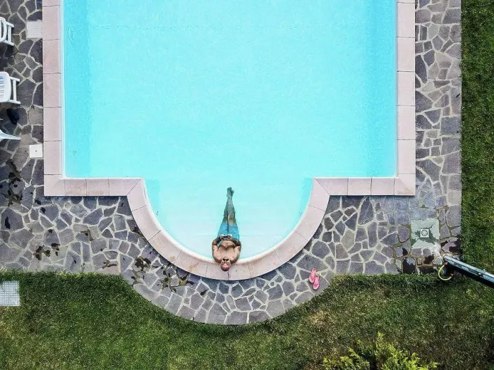 Framed Print : Drone view of man relaxing swimming pool Framed Print : Drone view of man relaxing swimming pool