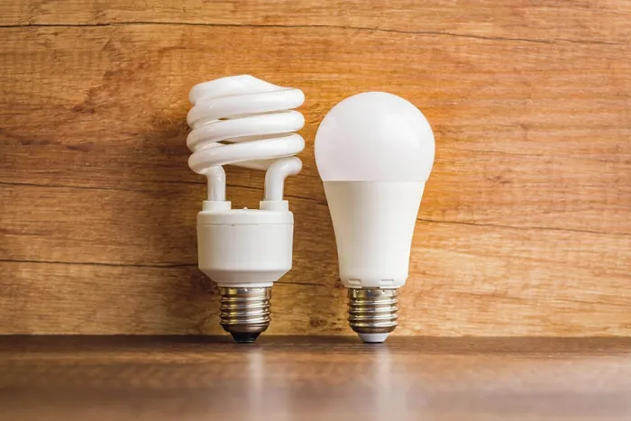 Framed Print : Energy saving light bulb. Fluorescent and led Lightbulb on wooden table Framed Print : Energy saving light bulb. Fluorescent and led Lightbulb on wooden table