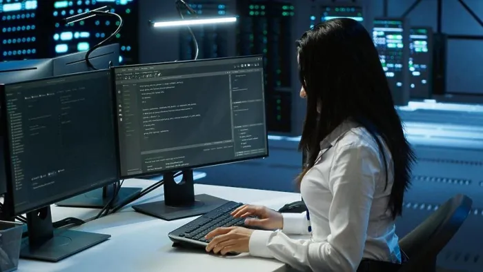 Framed Print : Engineer in data center sitting down at desk
