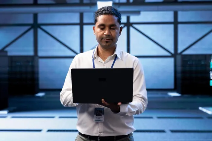 Framed Print : Engineer in server farm checking recovery plan on laptop