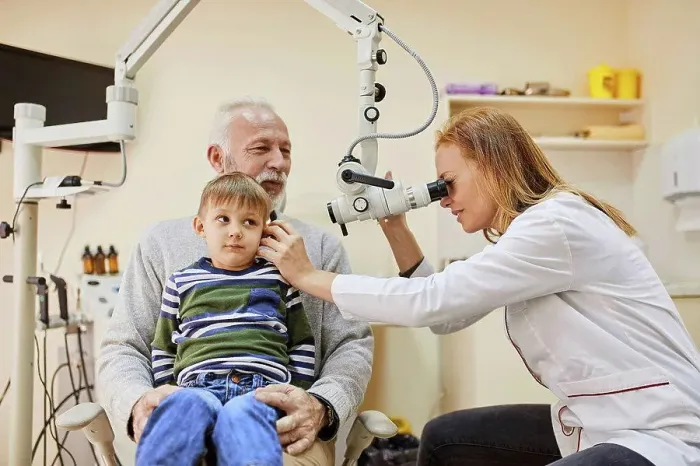 Framed Print : ENT physician examining ear of a boy sitting on grandfather's lap Framed Print : ENT physician examining ear of a boy sitting on grandfather's lap