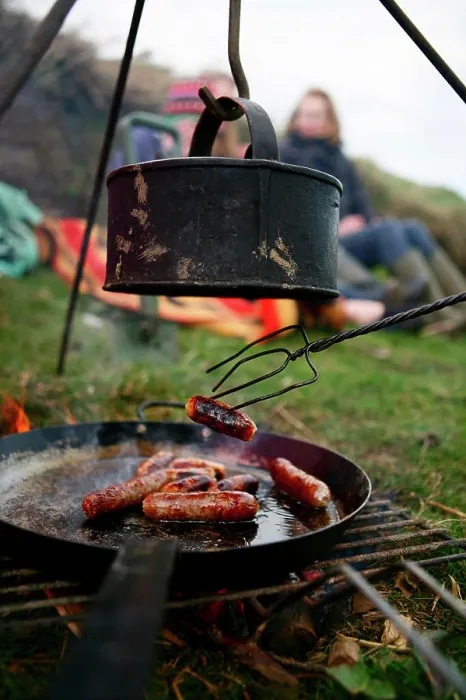 Framed Print : A family grills sausages and boils water on a camp fire near Ellingstring