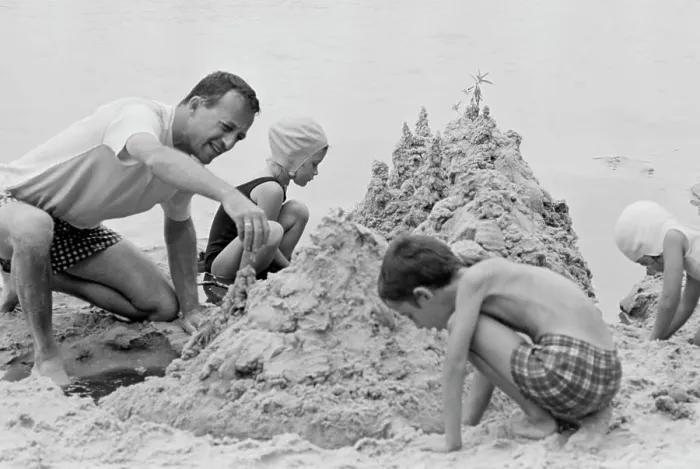 Framed Print : Father with three children building sand castle on beach Framed Print : Father with three children building sand castle on beach