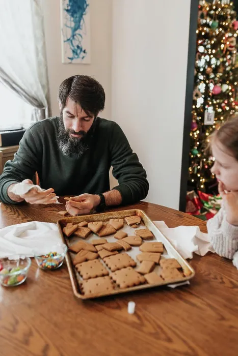 Framed Print : Father and daughter work together to build gingerbread house Framed Print : Father and daughter work together to build gingerbread house