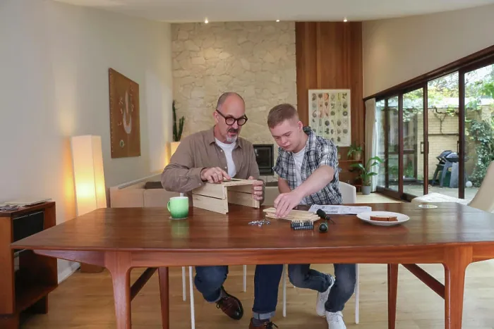 Framed Print : Father helping adult son to put together wooden box Framed Print : Father helping adult son to put together wooden box