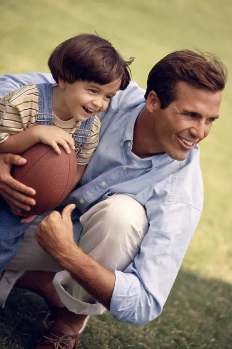 Framed Print : Father holding his daughter and a football