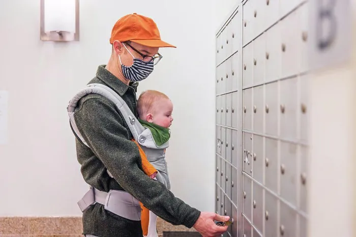 Framed Print : Father wearing face mask opening locker in room while carrying baby girl during COVID-19 crisis Framed Print : Father wearing face mask opening locker in room while carrying baby girl during COVID-19 crisis