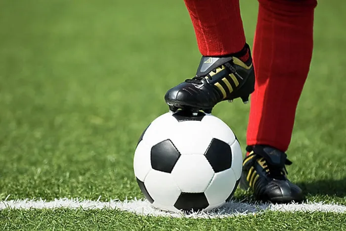 Framed Print : Feet of a football player in red socks and a classic black-and-white football Framed Print : Feet of a football player in red socks and a classic black-and-white football