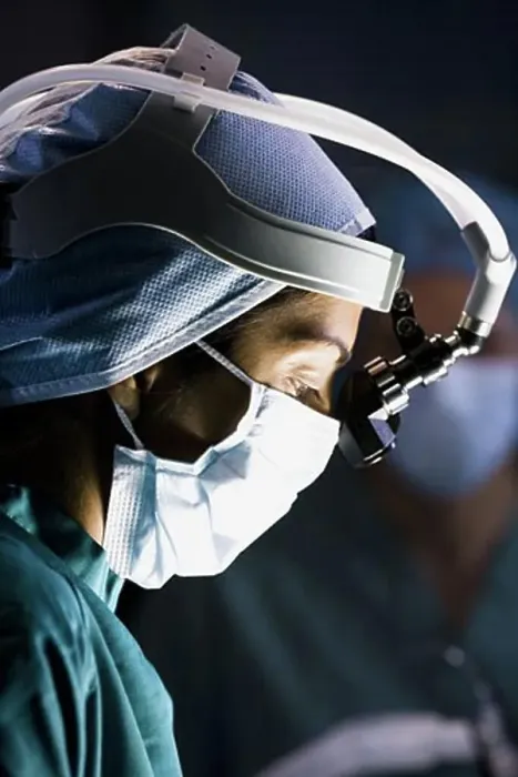 Framed Print : Female doctor in scrubs with head light in surgery