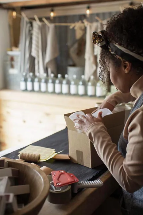 Framed Print : Female shop owner preparing package for shipping Framed Print : Female shop owner preparing package for shipping