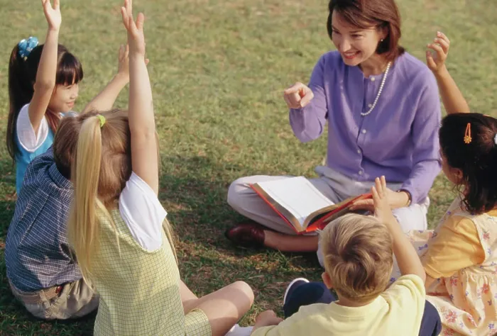 Framed Print : Female teacher playing with her students