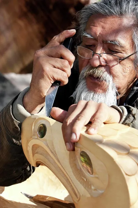 Framed Print : A First Nations carver works on an Eagle piece