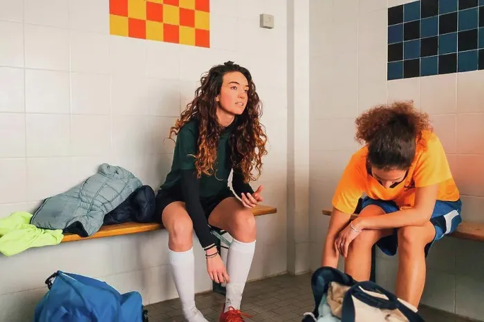 Framed Print : Football players on bench in changing room