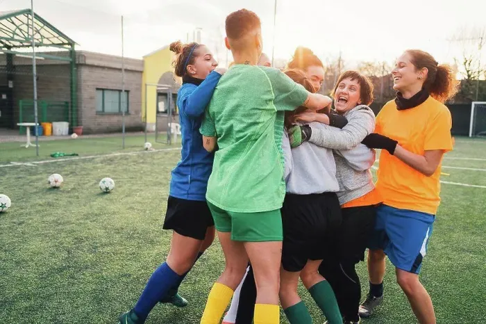 Framed Print : Football players jubilant and hugging on pitch