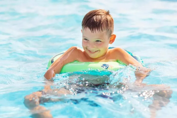 Framed Print : Funny happy child boy in swimming pool on inflatable rubber circle ring
