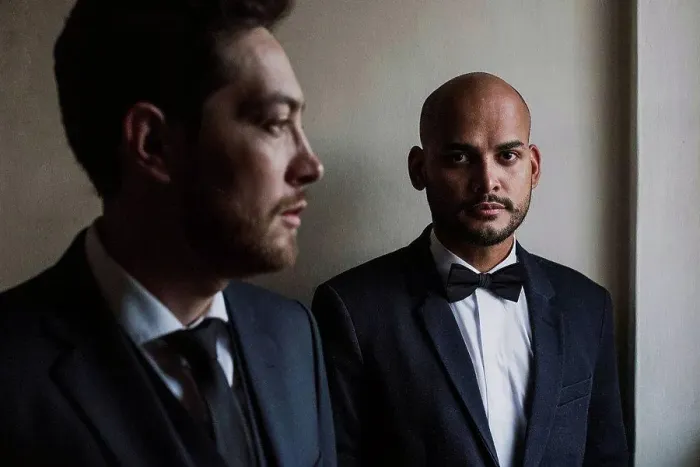 Framed Print : Gay couple in suits standing against wall on wedding day Framed Print : Gay couple in suits standing against wall on wedding day