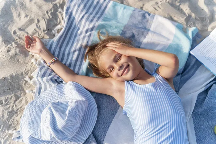 Framed Print : A girl on the beach is resting on a towel and smiling Framed Print : A girl on the beach is resting on a towel and smiling
