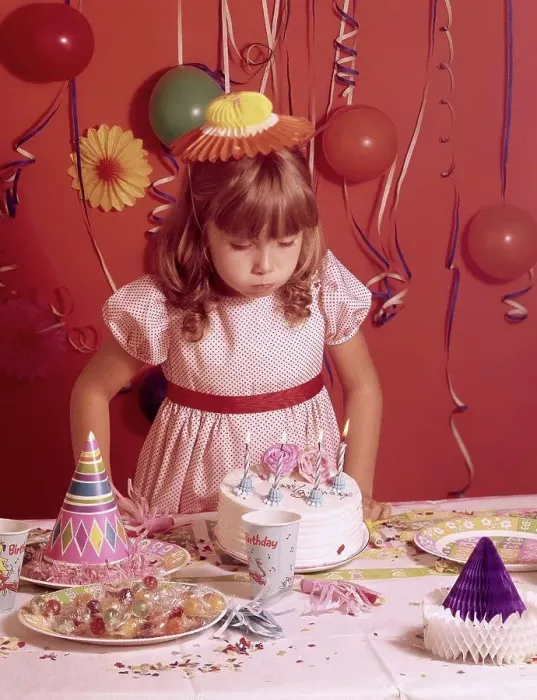 Framed Print : Girl blowing out candles on a birthday cake