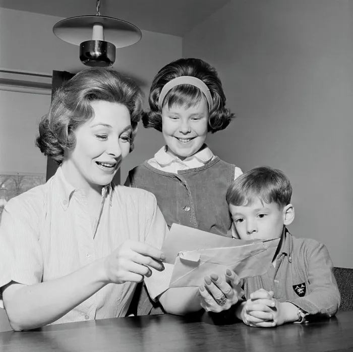 Framed Print : Girl and boy are watching as cheerful mother is reading letter
