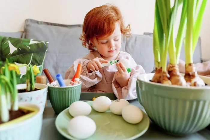 Framed Print : Girl coloring egg during Easter at home