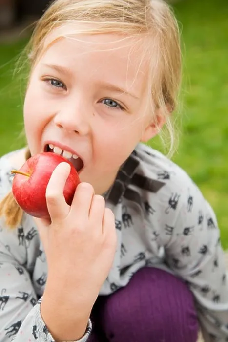 Framed Print : Girl eating fruit outdoors Framed Print : Girl eating fruit outdoors