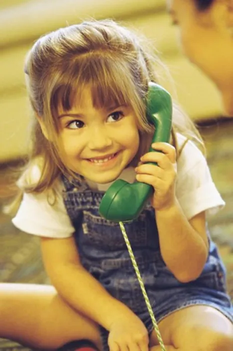 Framed Print : Girl holding a telephone receiver smiling Framed Print : Girl holding a telephone receiver smiling