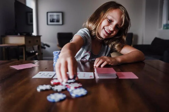 Framed Print : Girl playing cards at table, placing gambling chips Framed Print : Girl playing cards at table, placing gambling chips