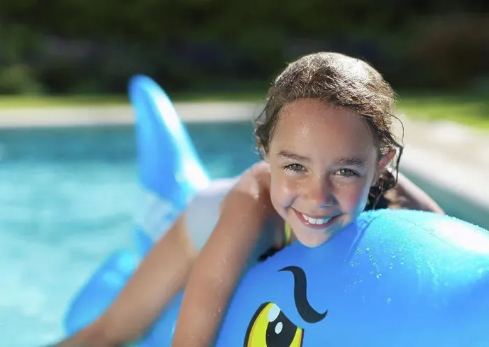 Framed Print : Girl riding inflatable toy in swimming pool