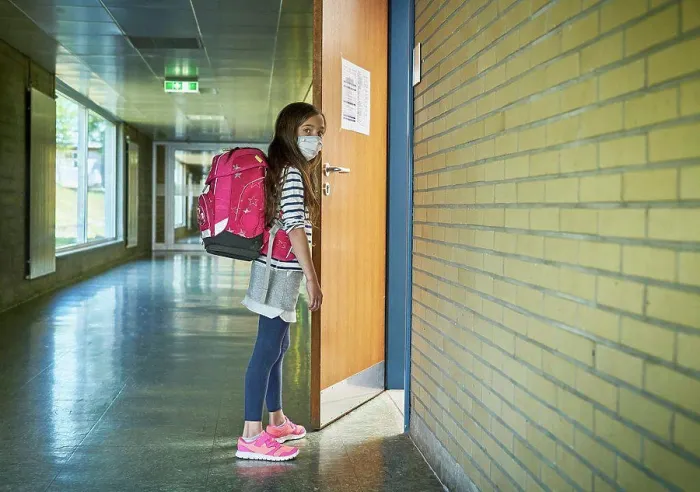 Framed Print : Girl wearing mask in school opening classroom door