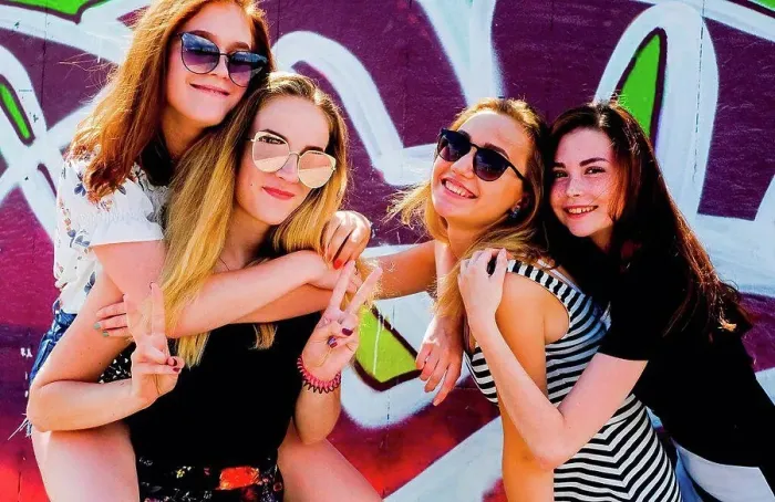 Framed Print : Girlfriends frolicking against graffiti wall