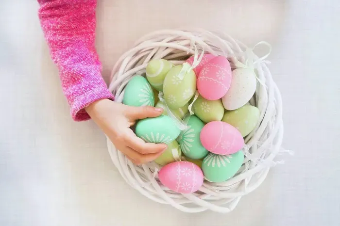Framed Print : Girl's hand taking coloured Easter egg Framed Print : Girl's hand taking coloured Easter egg