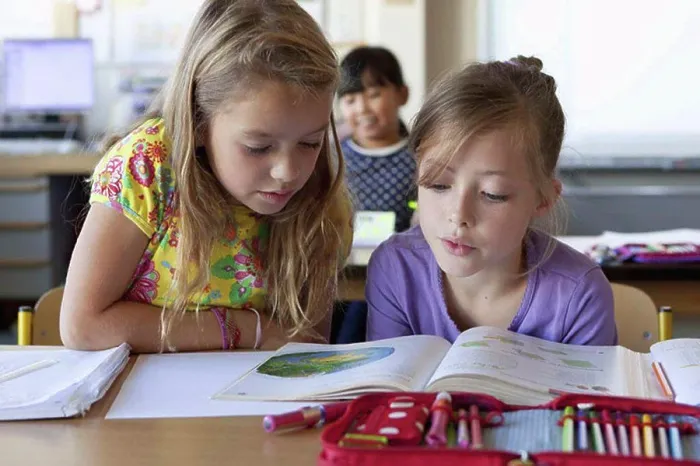 Framed Print : Girls reading book in classroom Framed Print : Girls reading book in classroom