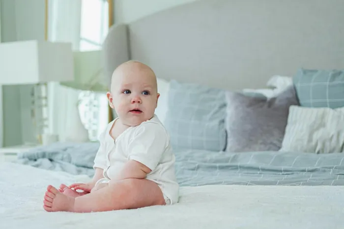 Framed Print : Glückliches Baby. Nettes kleines neugeborenes Mädchen mit lächelndem Gesicht sitzt auf dem Bett im Schlafzimmer Framed Print : Glückliches Baby. Nettes kleines neugeborenes Mädchen mit lächelndem Gesicht sitzt auf dem Bett im Schlafzimmer