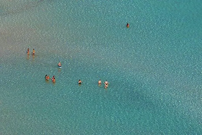 Framed Print : Green lagoon, single people standing in shallow water