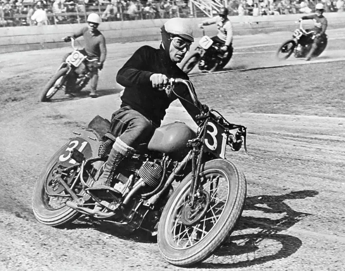 Framed Print : A grim-faced motorcycle racer skids through a turn as he leads the field on a 'figure 8' race track Framed Print : A grim-faced motorcycle racer skids through a turn as he leads the field on a 'figure 8' race track