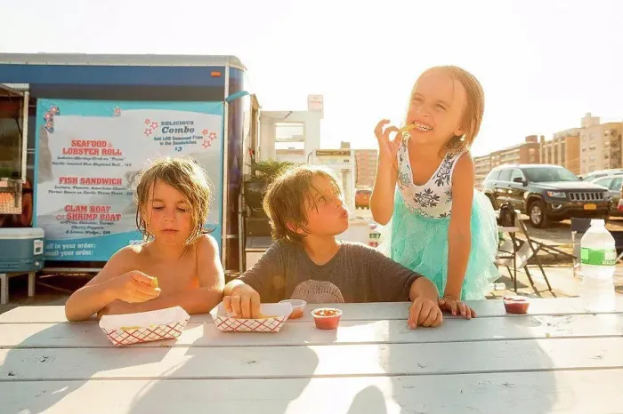 Framed Print : Group of children eating fast food beside fast food trailer Framed Print : Group of children eating fast food beside fast food trailer