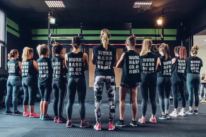 Framed Print : Group of women training in gym, wearing slogan t-shirts, rear view