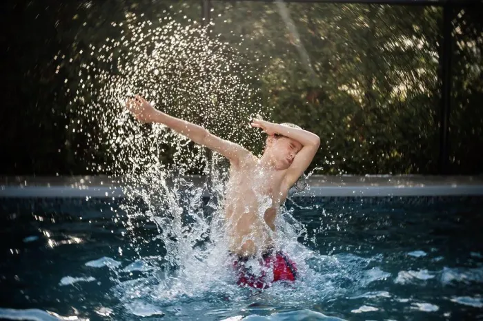 Framed Print : happy 8 years old boy having fun in a swimming pool during summer