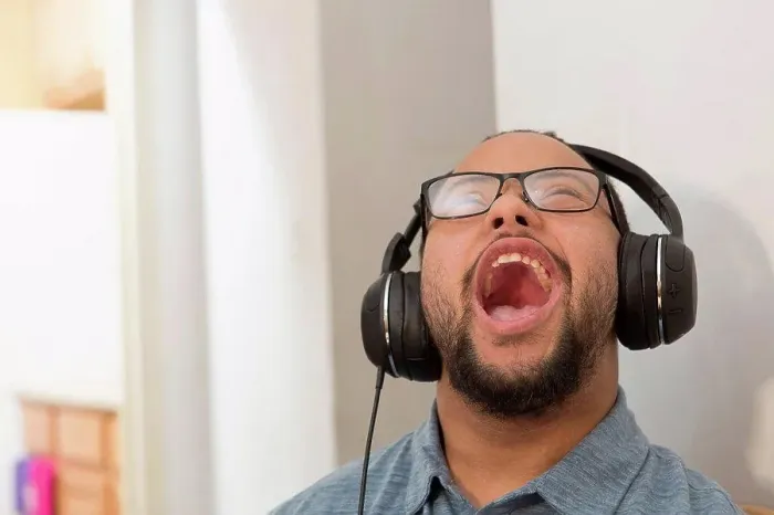 Framed Print : Happy African American man with Down Syndrome listening to music and singing with headphones at home Framed Print : Happy African American man with Down Syndrome listening to music and singing with headphones at home