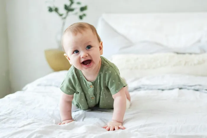 Framed Print : Happy baby. Nice little newborn girl with a smiling face crawls on the bed in the bedroom Framed Print : Happy baby. Nice little newborn girl with a smiling face crawls on the bed in the bedroom
