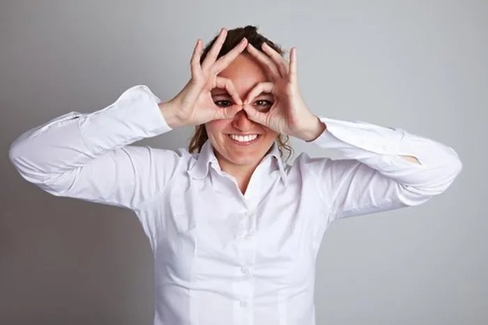 Framed Print : Happy business woman making circles with her fingers around her eyes Framed Print : Happy business woman making circles with her fingers around her eyes