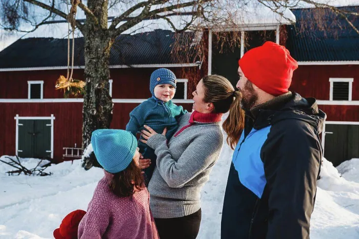 Framed Print : Happy family gathered by red Scandinavian bar in cold winter with snow